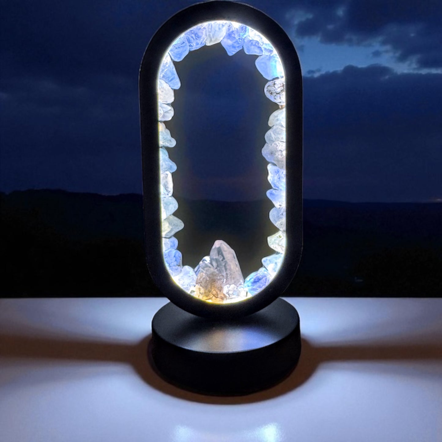 Celestite quartz portal lamp with sky-blue glow and quartz crystals, creating a serene and uplifting ambiance in a dark setting.