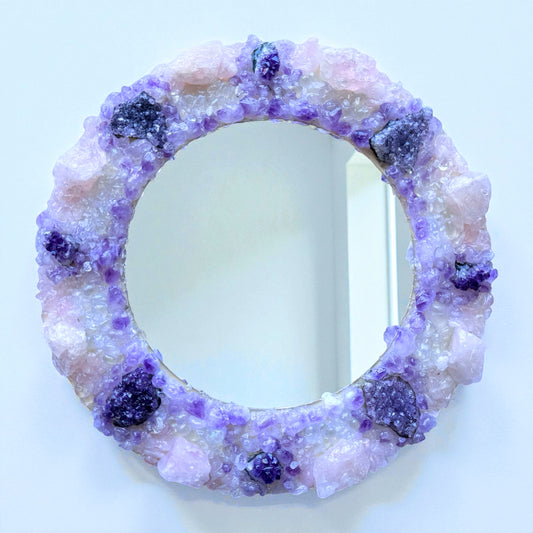 Crystal Mirror “Amethyst Bloom” with 28cm frame, featuring a blend of amethyst flowers, clusters, and rose quartz in a violet-pink palette.