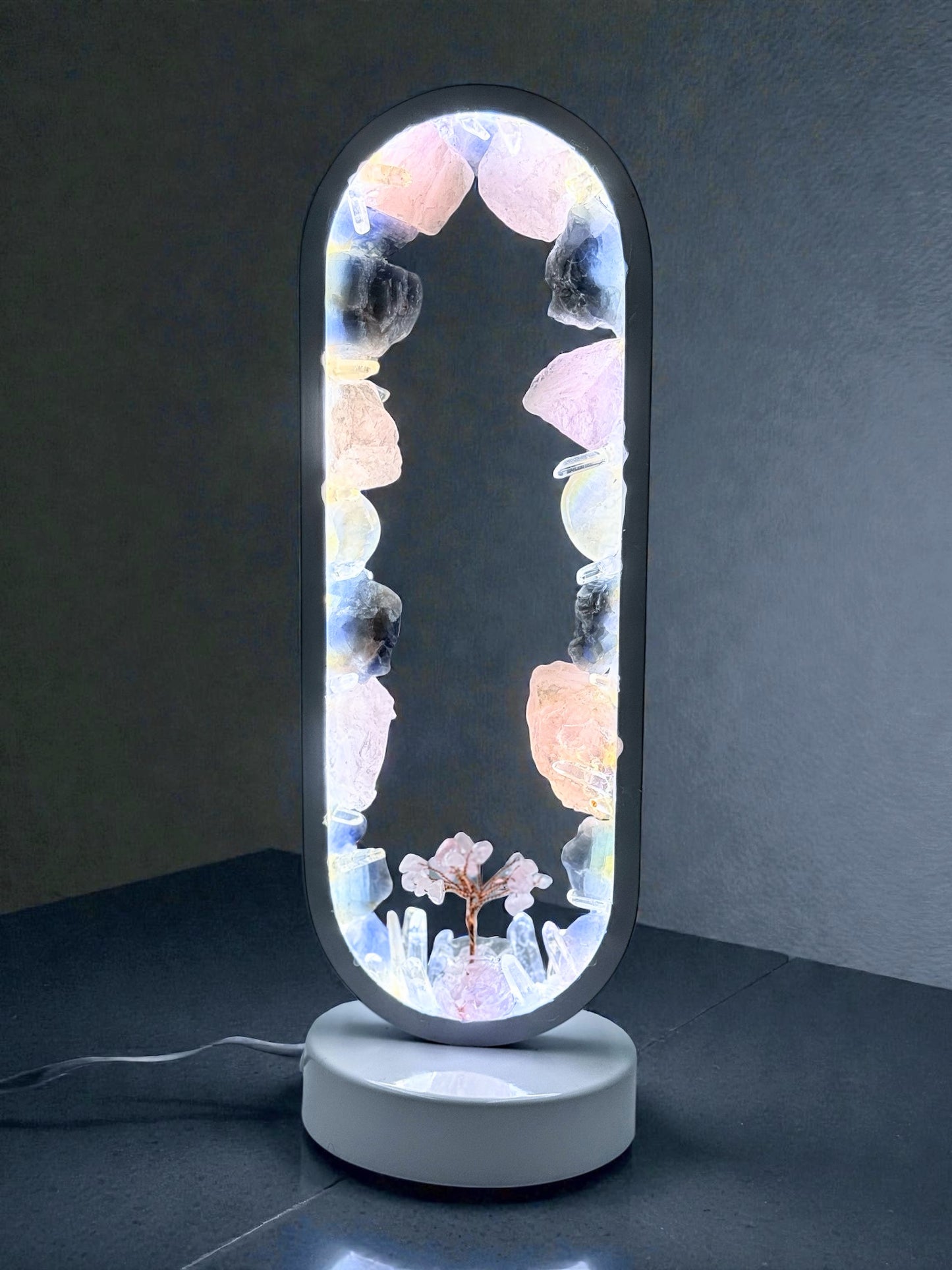 Crystal Portal Lamp "Twilight Grove" with rose quartz, blue calcite, and quartz crystals glowing on a dark background.