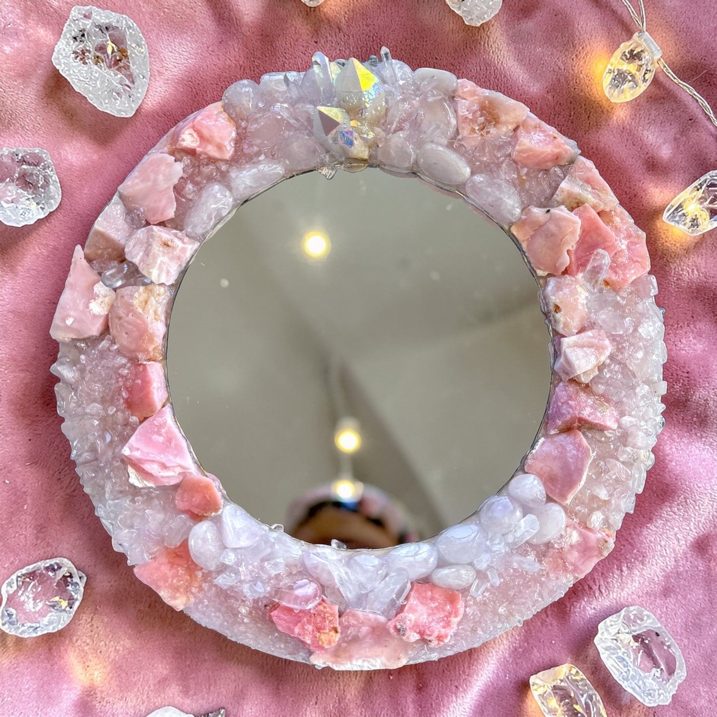 Angel Aura Crystal Mirror 28cm featuring Pink Opal, Rose Quartz, Clear Quartz, and Angel Aura Quartz cluster on pink fabric.