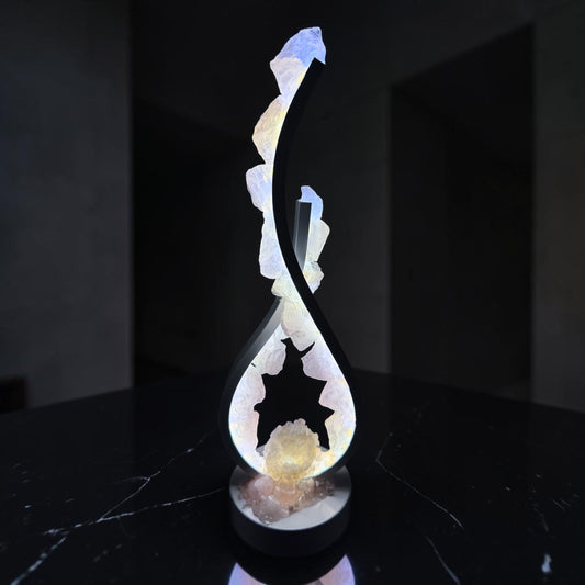 Crystal lamp with flowing design featuring rose quartz crystals and glowing center geode.