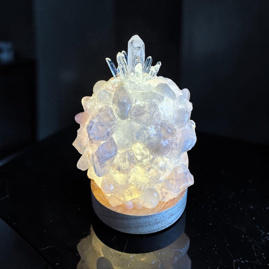 Crystal dome lamp illuminated, showcasing unique rose quartz and clear quartz crystals in a handcrafted design.