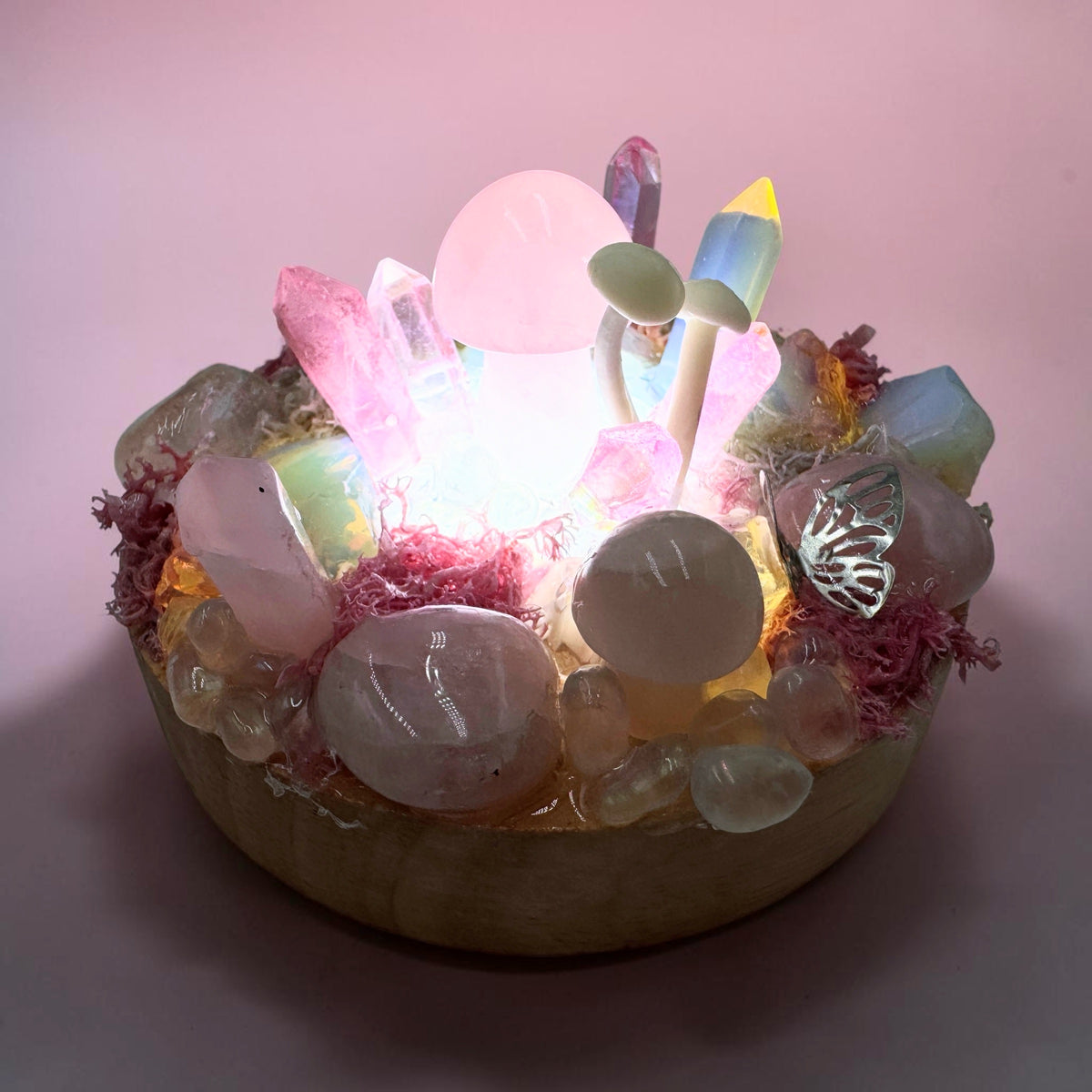 Fairy light garden rose quartz decoration featuring crystals and glowing elements in a miniature design.