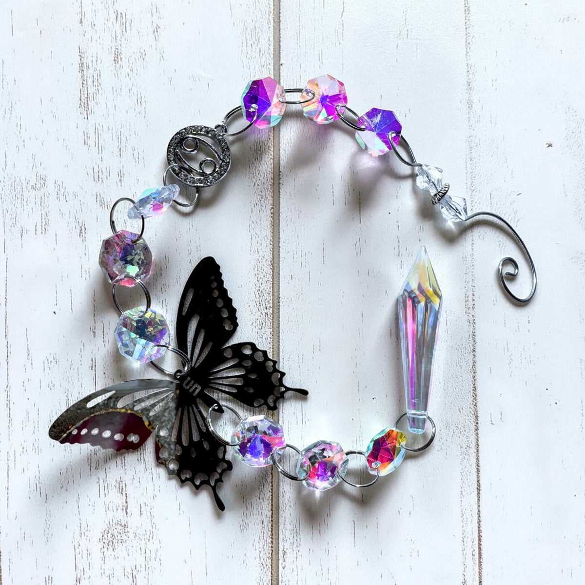 Star sign sun catcher featuring a silver butterfly, iridescent beads, and crystal prism for home decor.