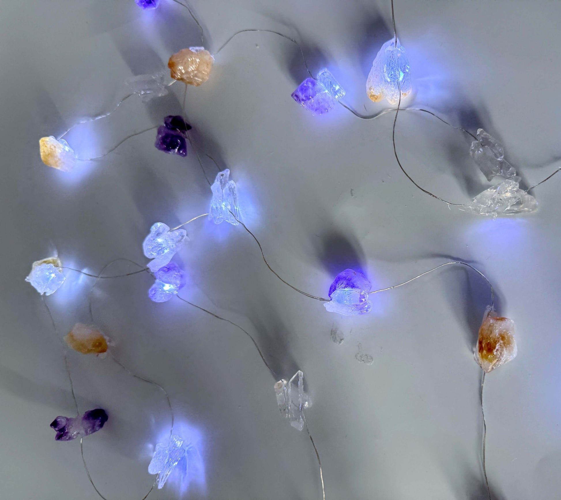 Crystal fairy lights with amethyst, citrine, and clear quartz providing a cool glow for balance and positivity. 3-meter length string.