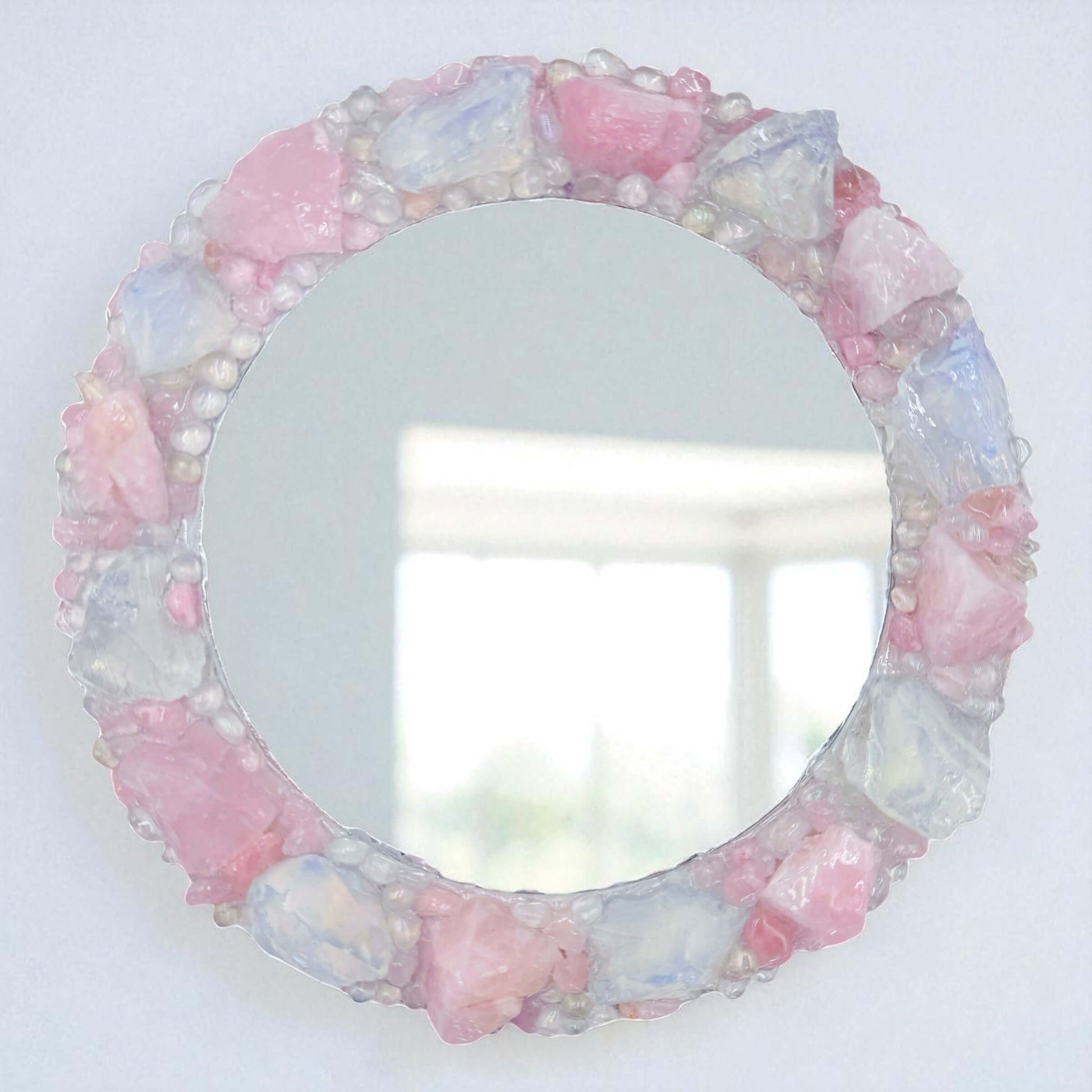 Handmade crystal mirror with gemstone border reflecting natural light