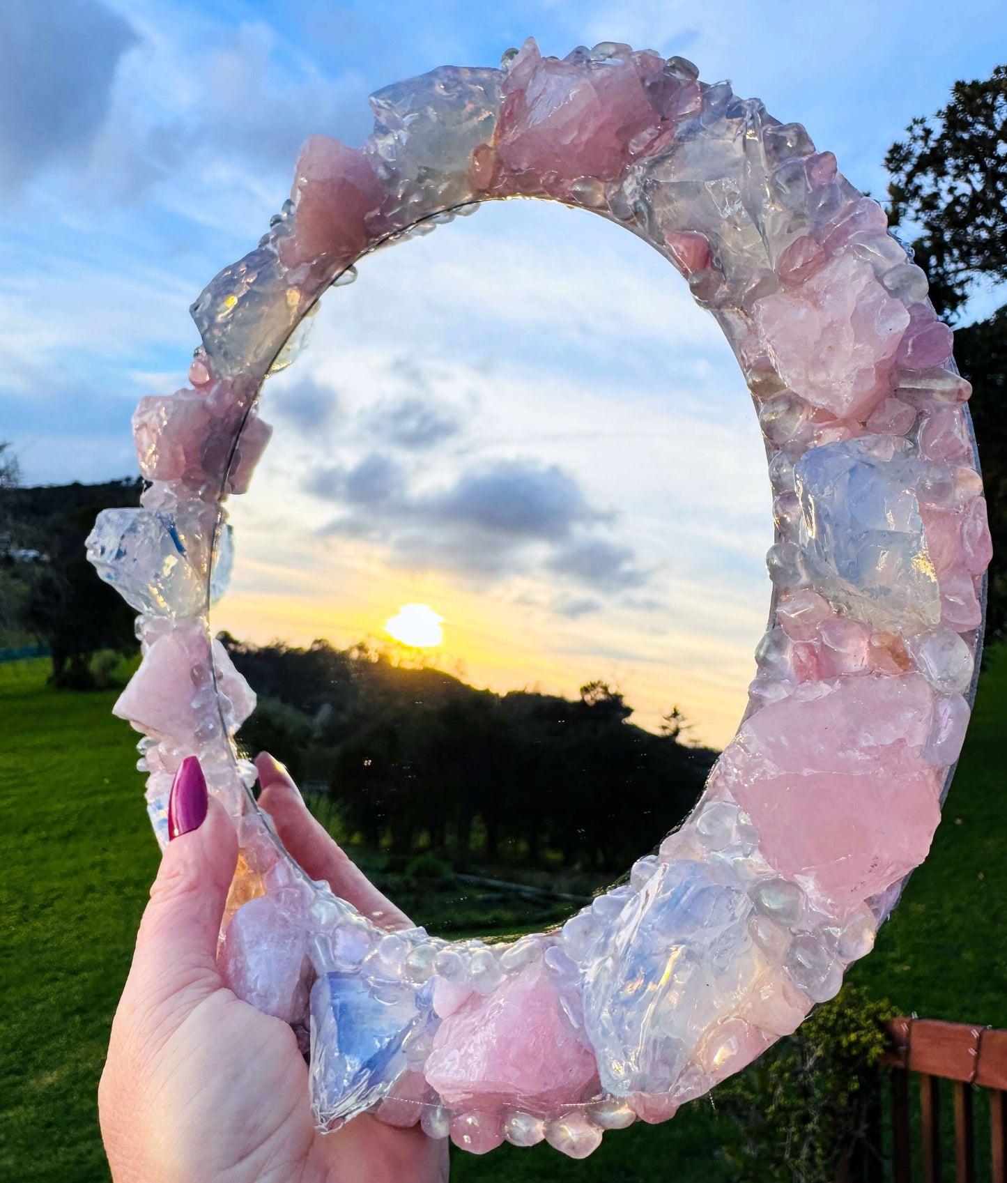 Handmade crystal mirror with gemstone border reflecting natural light