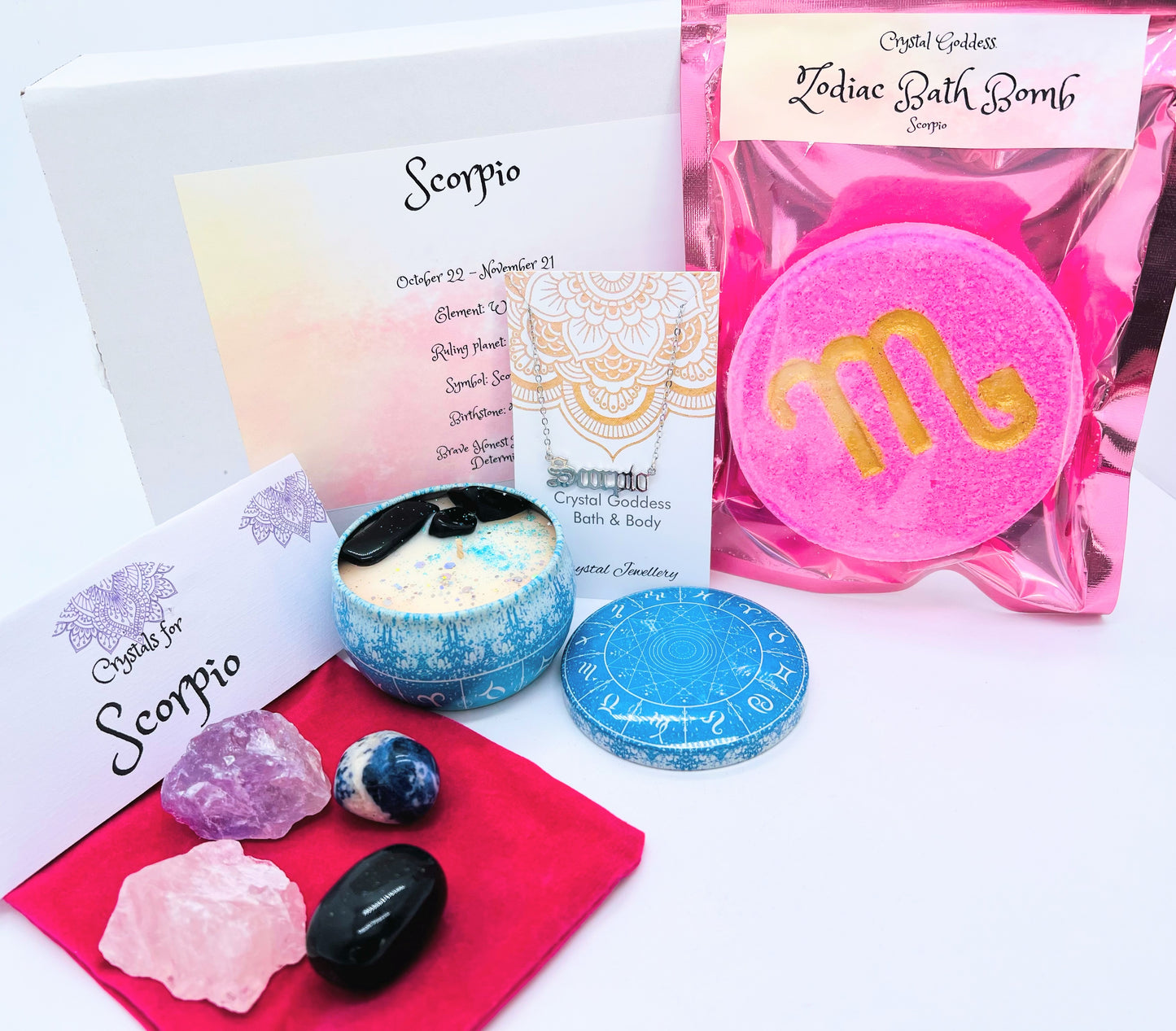 Scorpio zodiac gift box showing a set of four crystals, crystal candle, pendant and a bath bomb with the symbol for this sign on it.