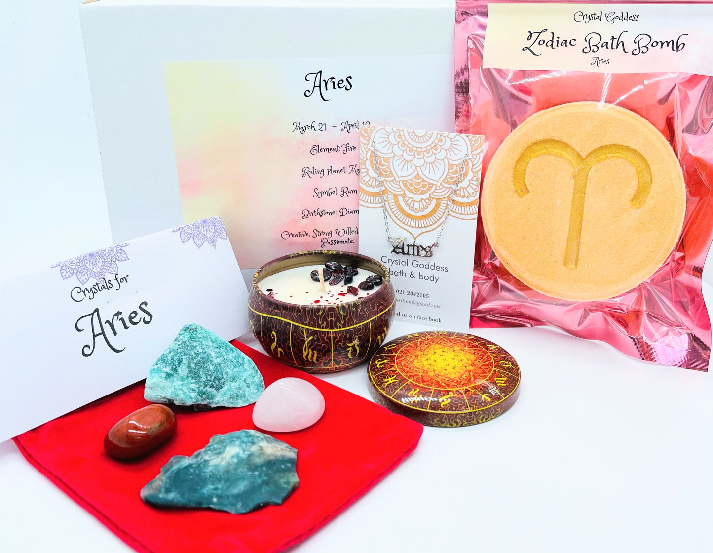 Aries zodiac gift box showing a set of four crystals, crystal candle, pendant and a bath bomb with the symbol for this sign on it.