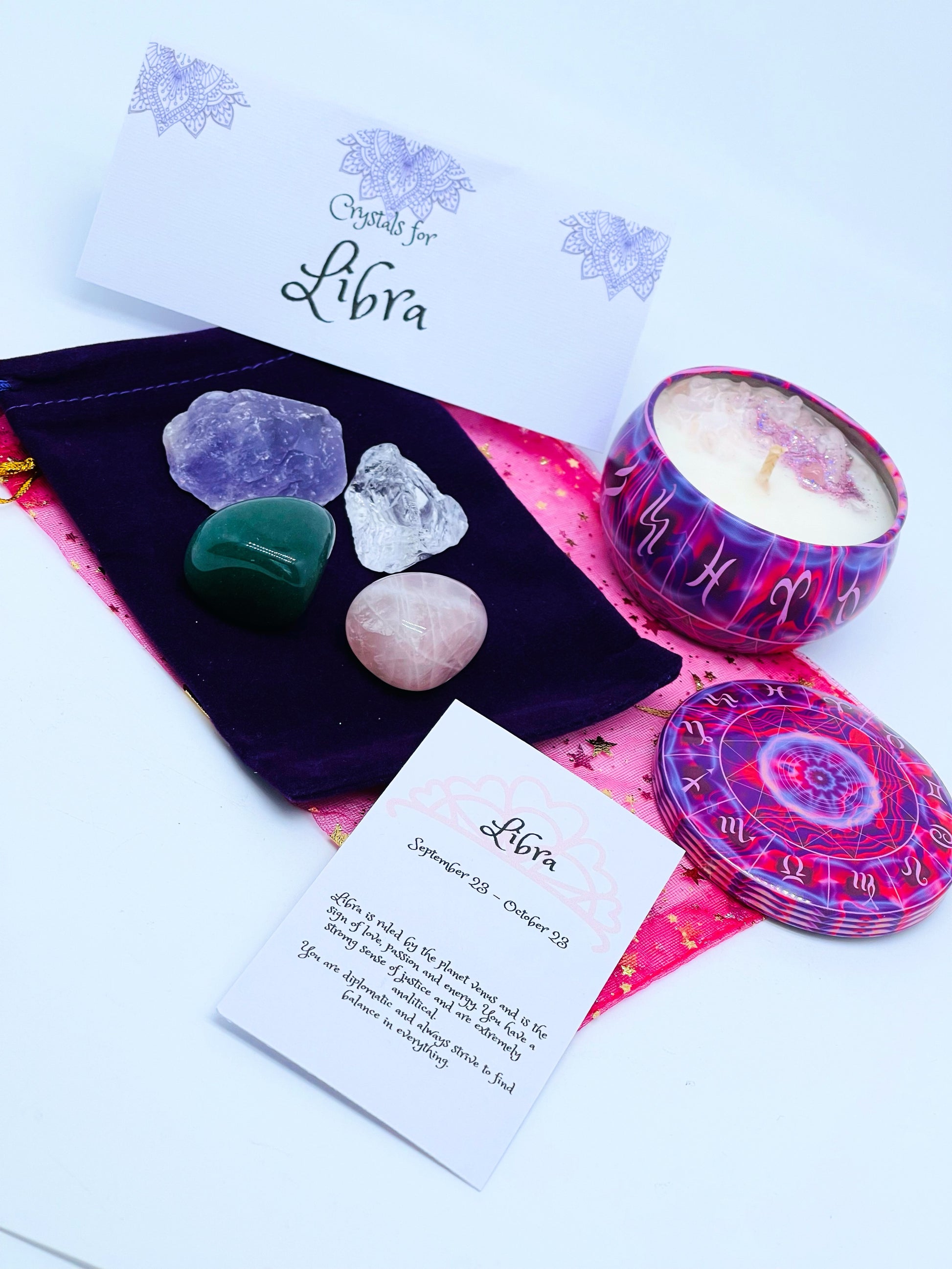 Libra zodiac candle gift set with candle and four crystals for this sign sitting on a velvet bag.