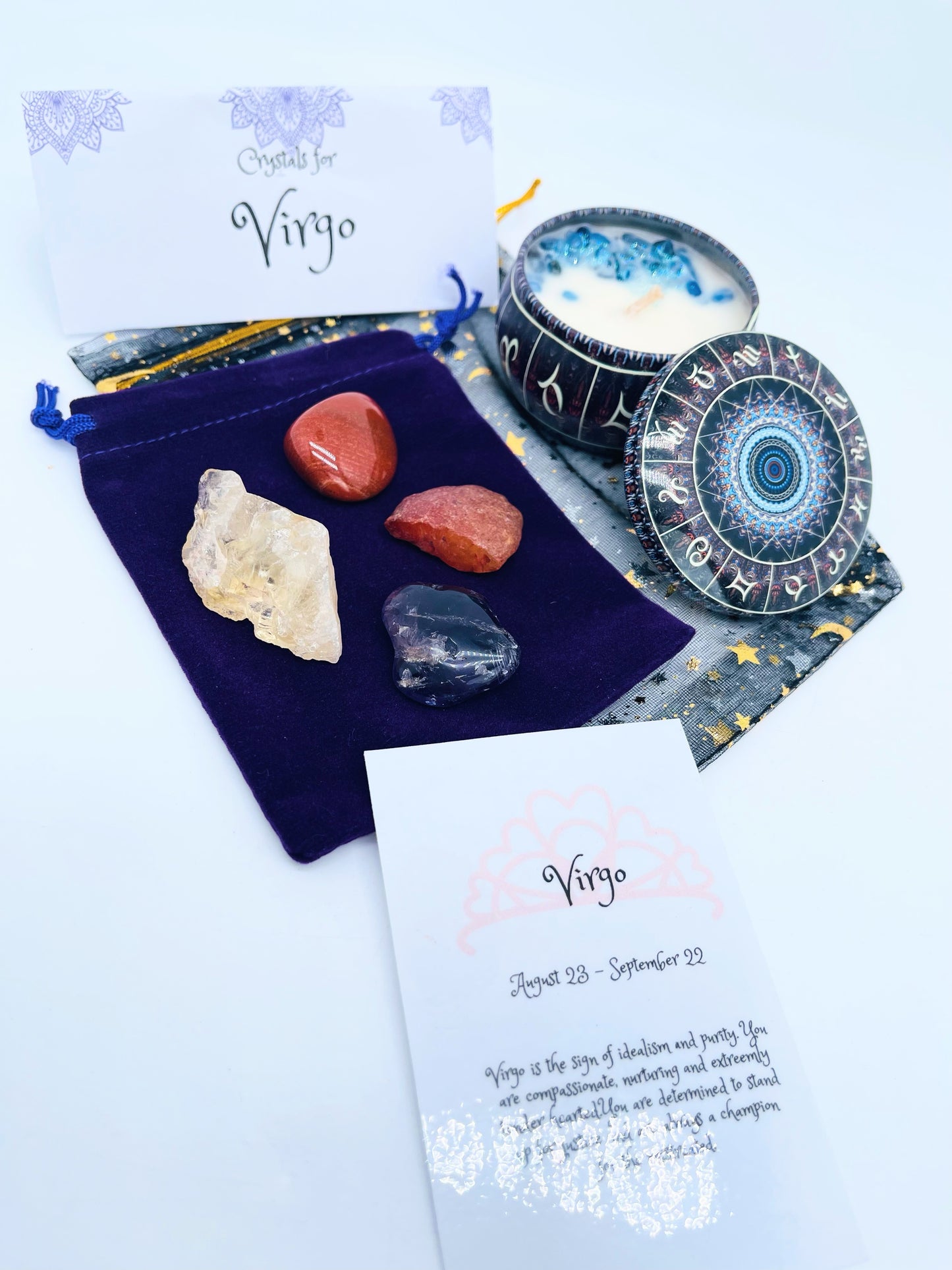 Virgo zodiac candle gift set with candle and four crystals for this sign sitting on a velvet bag.