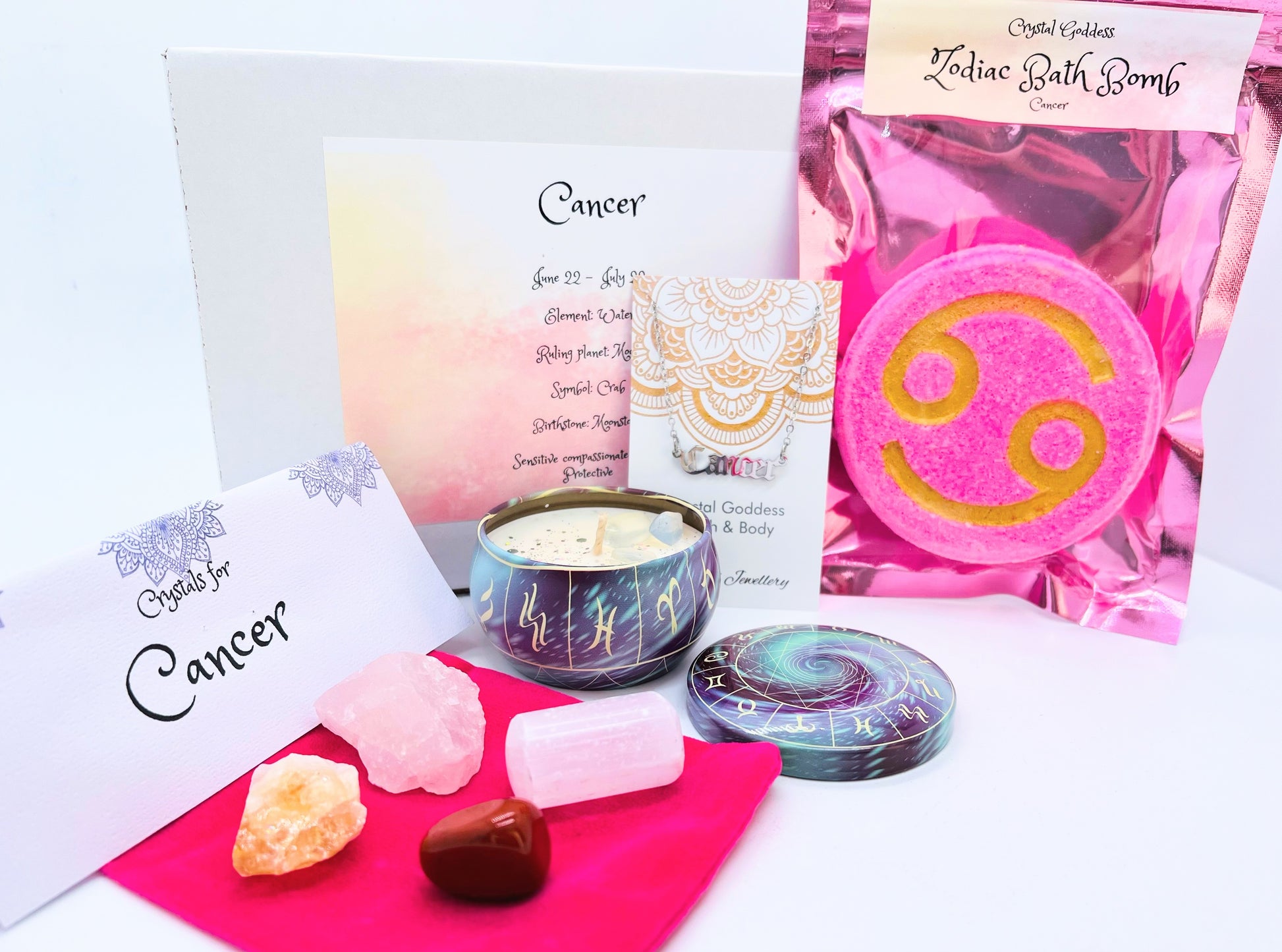 Cancer zodiac gift box showing a set of four crystals, crystal candle, pendant and a bath bomb with the symbol for this sign on it.