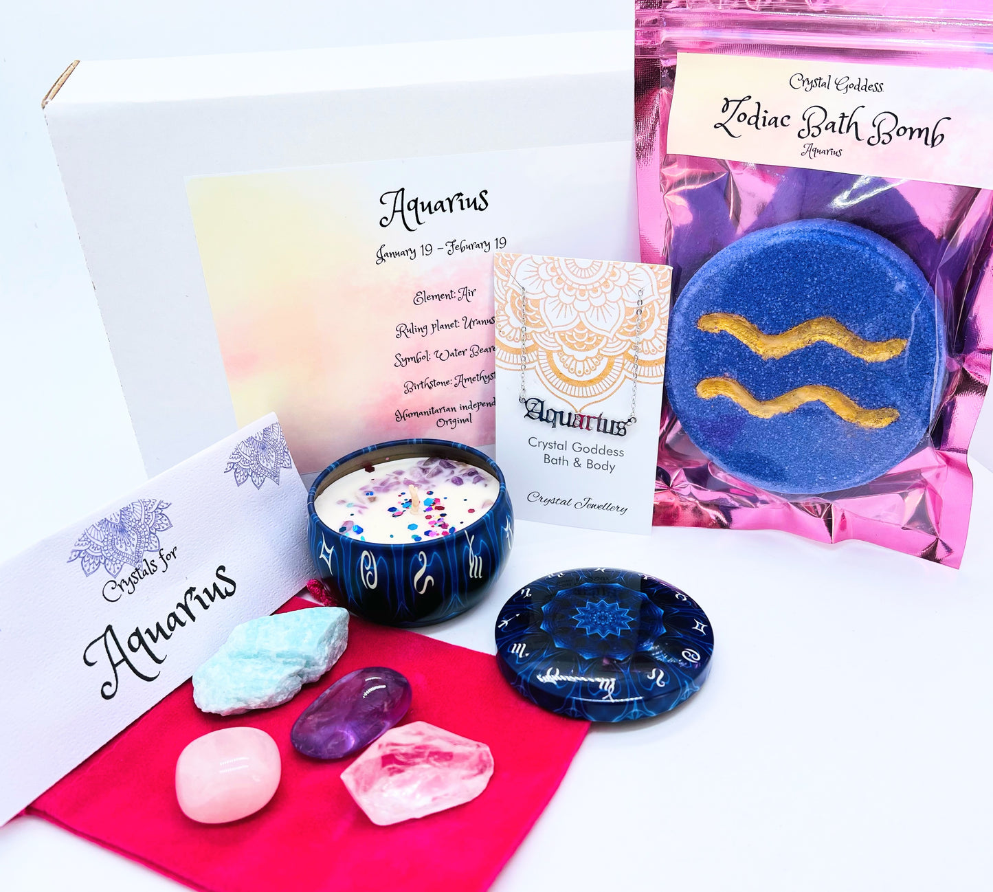 Aquarius zodiac gift box showing a set of four crystals, crystal candle, pendant and a bath bomb with the symbol for this sign on it.