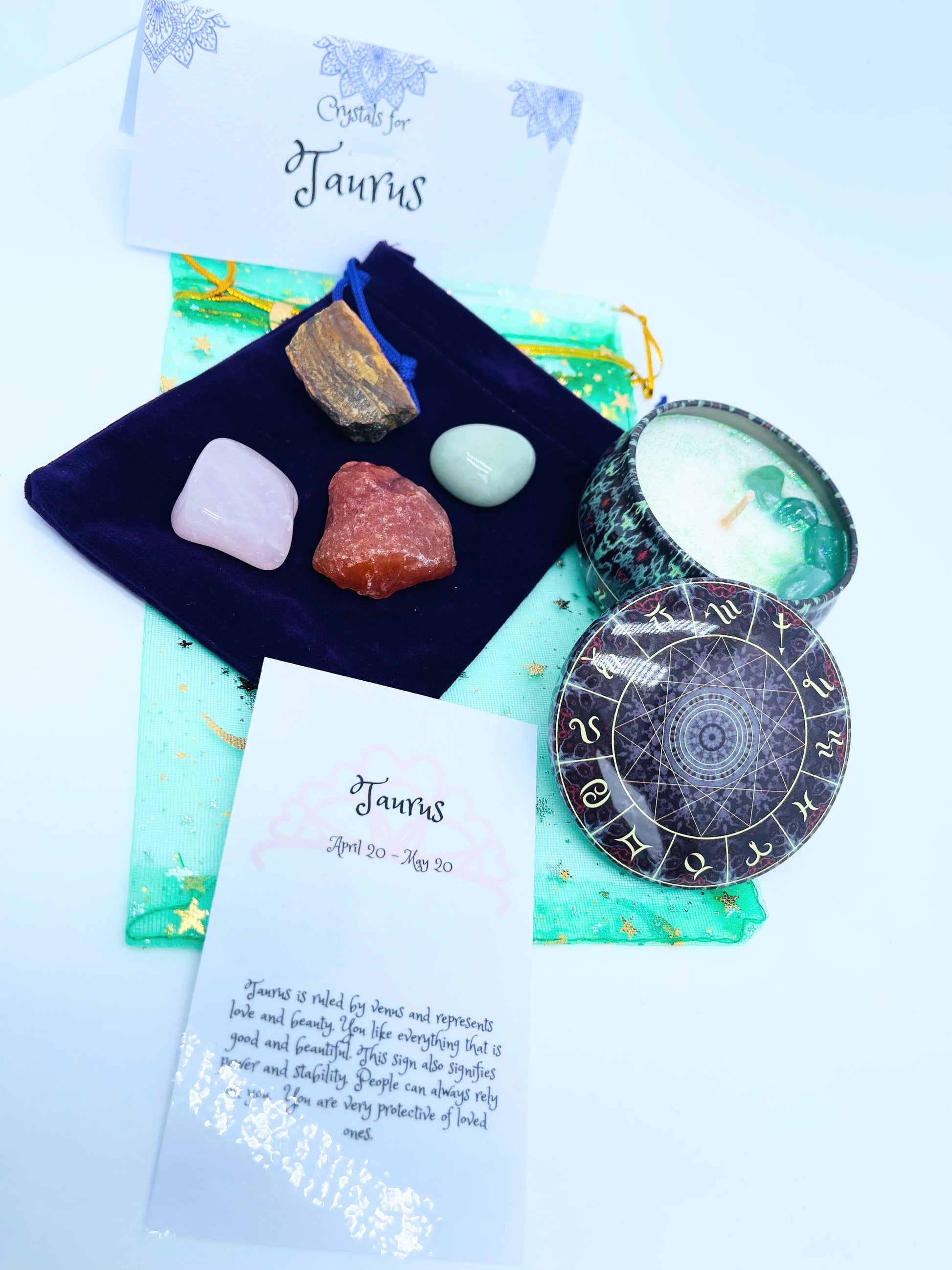 Taurus zodiac candle gift set with candle and four crystals for this sign sitting on a velvet bag.