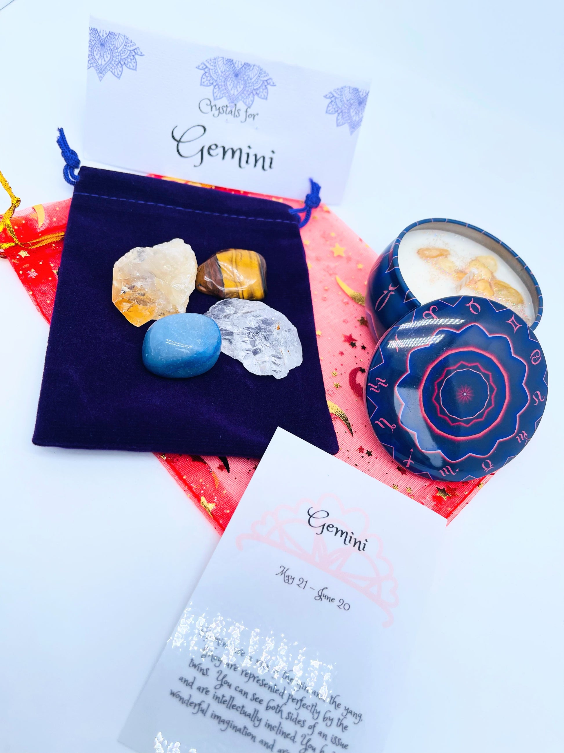 Gemini zodiac candle gift set with candle and four crystals for this sign sitting on a velvet bag.