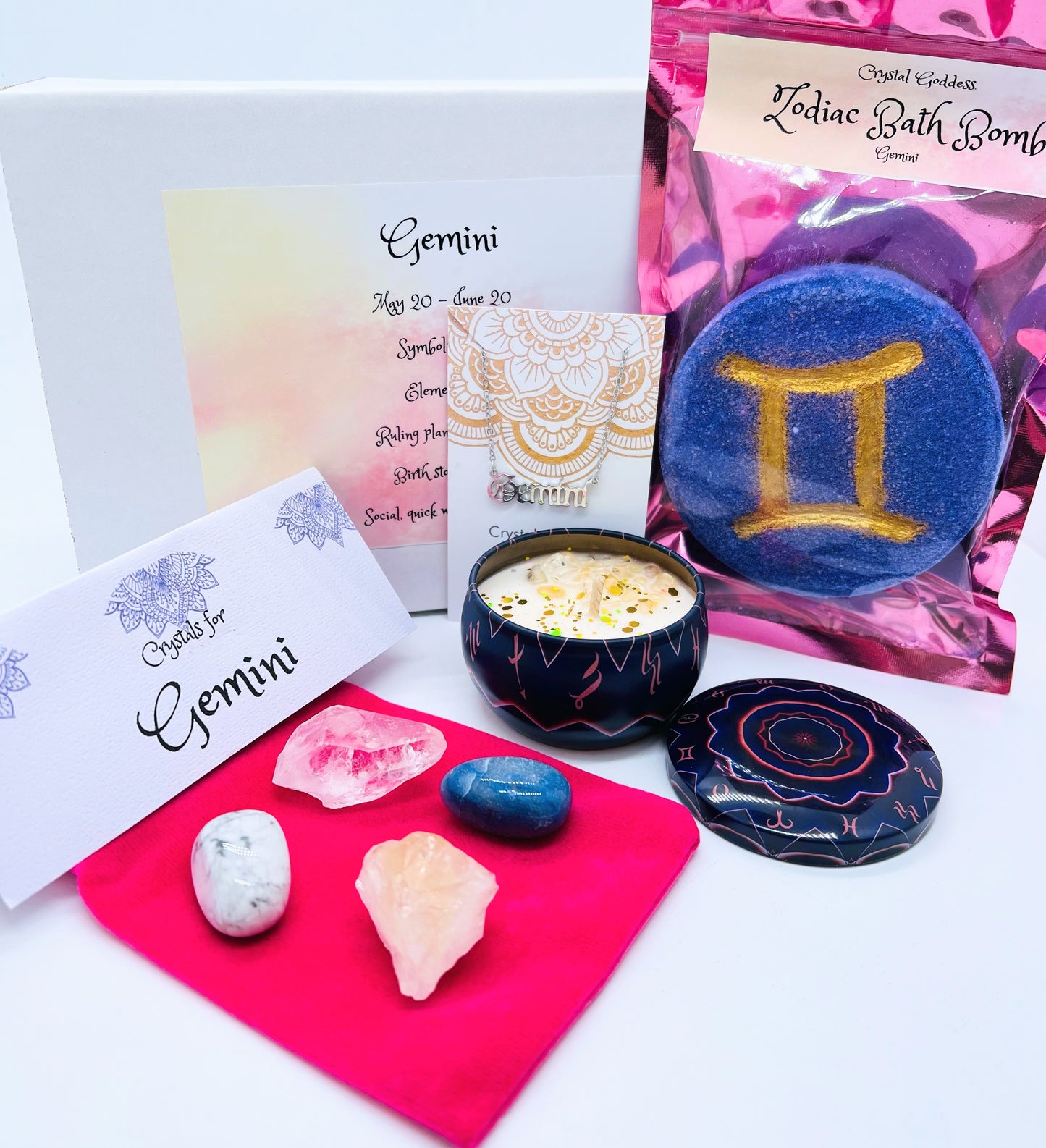 Gemini zodiac gift box showing a set of four crystals, crystal candle, pendant and a bath bomb with the symbol for this sign on it. 