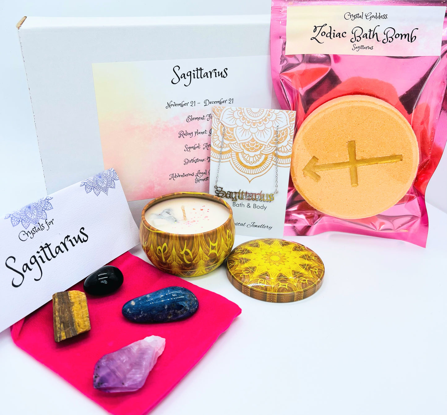 Sagittarius zodiac gift box showing a set of four crystals, crystal candle, pendant and a bath bomb with the symbol for this sign on it.