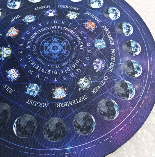 Close up Round dark blue pendulum mat with lunar phase and astrology design, used for divination, energy work, and crystal pendulum readings.